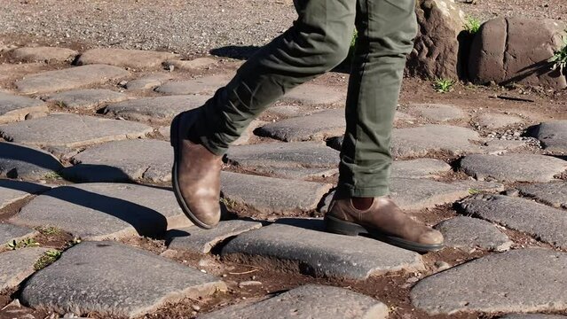Passeggiata sull'antico basolato romano e sui sampietrini. Piedi che camminano.
Primo piano sulle scarpe da uomo. Ripresa al rallentatore.