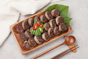  Food made by mixing meat, tofu, eggs, etc. in blood and putting them in the intestines of domestic animals and steaming or boiling them.
