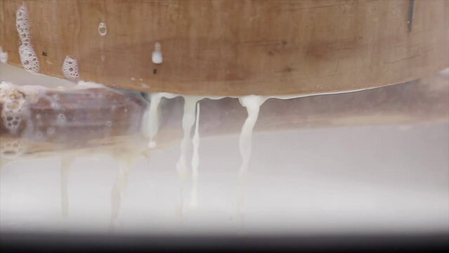 두부를 만들기위해 삶은 콩물을 채에 걸러 내자 채 아래로 콩물이 흐르는   