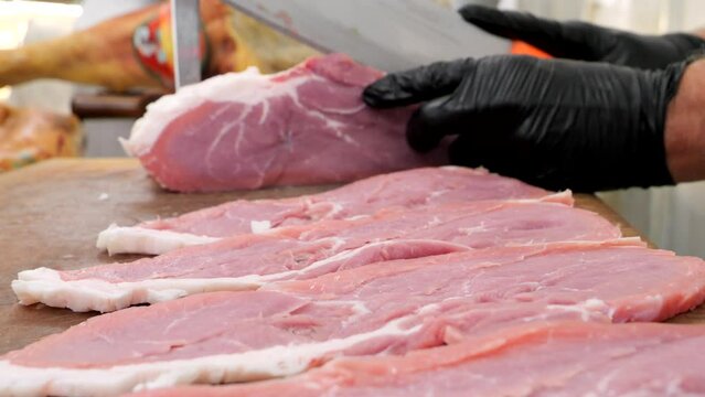 il Macellaio taglia le fettine di carne di vitella.
il coltello affilato prepara la carne per la vendita.