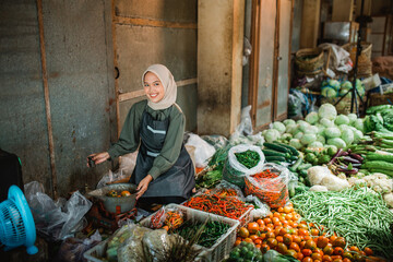 potrait of asian seller weighing fresh products in vegetable stall