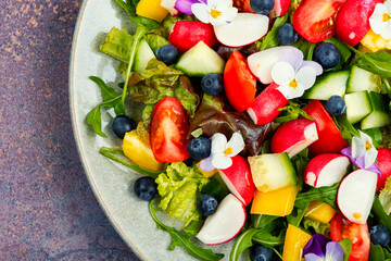 Summer salad with edible flowers, healthy food.