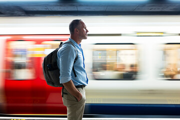 Mature businessman standing with hand in pocket on platform