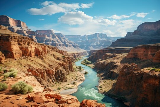  a river flowing through a canyon next to a rocky cliff under a blue sky with a few clouds in the sky.