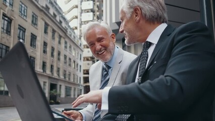 Cinematic image of senior businessmen at work in London. Business man entrepreneur making deals with partners over future investments. Concepts about finance, entrepreneurship and lifestyle.