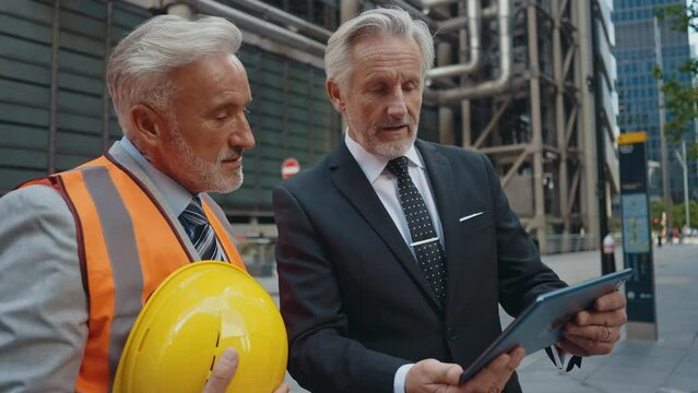 Cinematic image of senior businessmen at work in London. Business man entrepreneur making deals with partners over future investments. Concepts about finance, entrepreneurship and lifestyle.