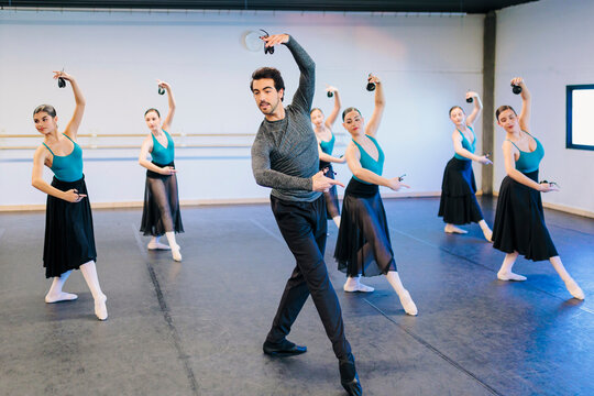 Instructor dancing with flamenco dancers in studio