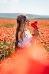 Woman poppies field. Side view of a happy woman with long hair in a poppy field and enjoying the...