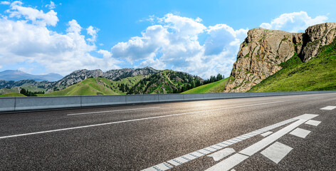 Asphalt highway road and mountain nature landscape under blue sky