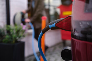 Electric plug connected to car charging at station