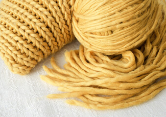 Knitting, scarf and ball of yellow yarn.