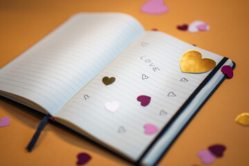 Notebook with Valentine's Day notes. Heart-shaped paper cutouts. Love sign. To celebrate Valentine's Day