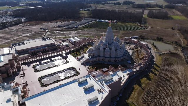 An aerial view of the Shri Swaminarayan Mandir in Robbinsville Twp, NJ on a sunny day, it was closed for the day. The camera truck left and pan right orbiting the temple clockwise.