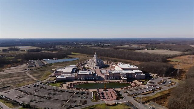 An aerial view of the Shri Swaminarayan Mandir in Robbinsville Twp, NJ on a sunny day, it was closed for the day. The camera dolly in then truck left in the direction of the temple.