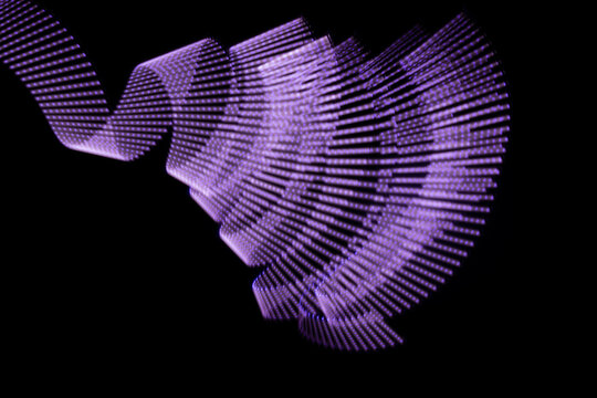 Violet glow neon wave of light as funnel or swirl with dotted stripes on black background. Abstract background with flowing line in motion, light painting in vapor wave style.