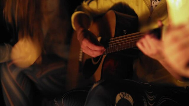 A man's hand is playing the guitar.