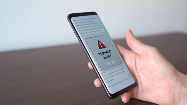 Tornado alert notification appearing on the phone while in use. Danger and bad weather concept.