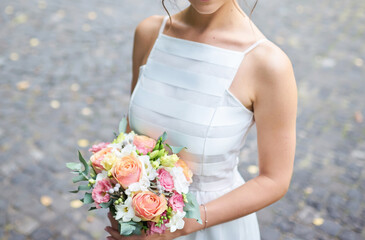 Tender hands cradle a bridal bouquet