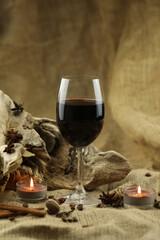 Glass of red wine with spice. Cloth background with copy space