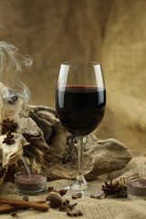 Glass of red wine with spice. Cloth background with copy space