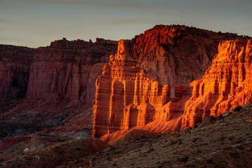 Sandstone formations in an arid canyon landscape at sunset