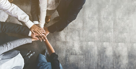 Business people putting their hands together, top view - Powered by Adobe
