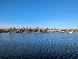 Obraz premium Rio com algumas casas entre árvores no outro lado da margem em Pau, na Nova Aquitânia em França