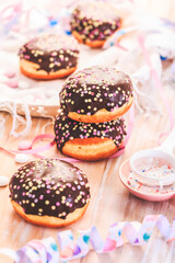 German Krapfen or donuts with streamers and confetti. Traditional Berliner for carnival and party.