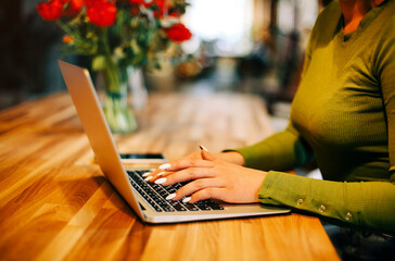 Cheerful freelancer using laptop in cafe