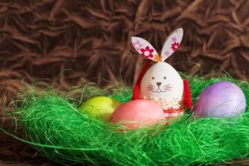 Fototapeta na wymiar Colorful Easter eggs, green nest and bunny rabbit