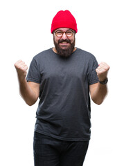 Young caucasian hipster man wearing glasses over isolated background celebrating surprised and amazed for success with arms raised and open eyes. Winner concept.