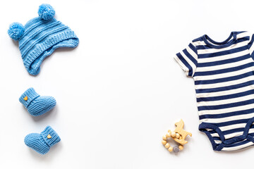Set of baby boy dress - blue bodysuit with knitted hat and boots, top view. Kids clothing flat lay