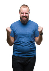 Fototapeta premium Young caucasian hipster man over isolated background celebrating surprised and amazed for success with arms raised and open eyes. Winner concept.