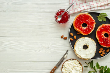 Fresh bagels with cheese cream and jam. Homemade bread background
