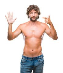 Handsome hispanic model man sexy and shirtless over isolated background showing and pointing up with fingers number seven while smiling confident and happy.