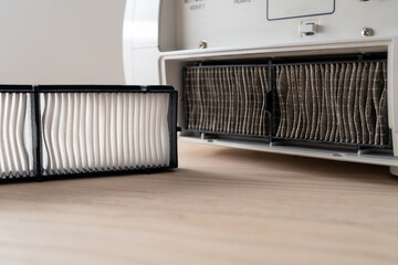 Home appliance service and repair concept. The new air filter is ready to replace the old filter in...