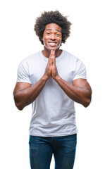 Afro american man over isolated background praying with hands together asking for forgiveness smiling confident.