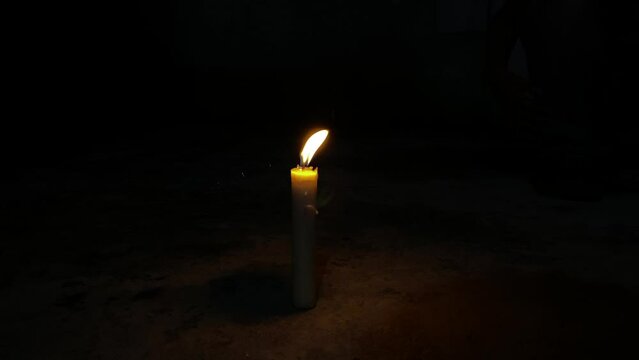 Close-up of a flame burning on a candle and going out due to being blown out on an isolated black background. Candle flame in the dark. fire on black background.