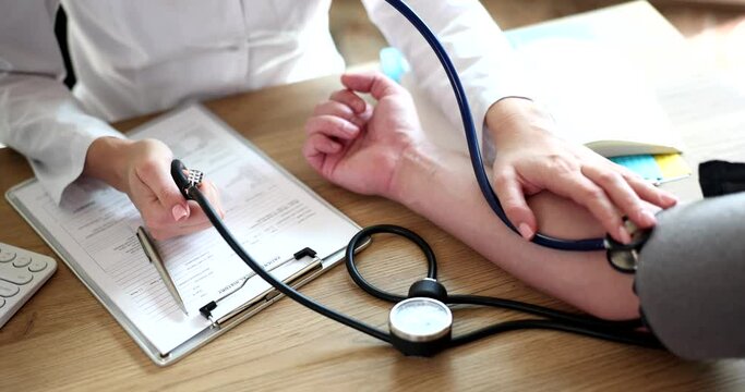 Therapist cardiologist using tonometer checks patient blood pressure. Arterial hypertension and syndrome of increased clinical arterial pressure