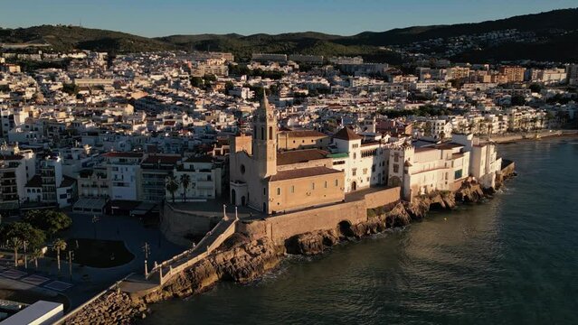 Drone approaching San Bartolome and Santa Tecla Church, Sitges Town sunrise