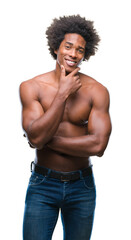 Fototapeta premium Afro american shirtless man showing nude body over isolated background looking confident at the camera with smile with crossed arms and hand raised on chin. Thinking positive.