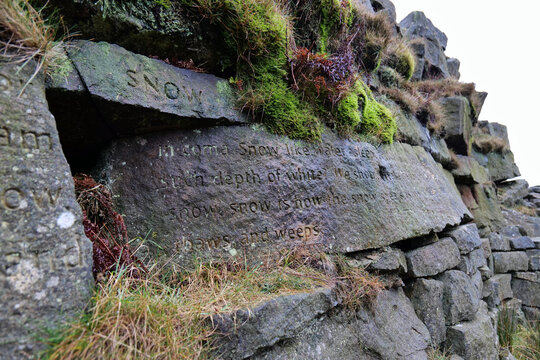 Marsden, UK 01 15 2024 : Half of the now weathered 'SNOW' Stanza Stone at Pule Hill outside of Marsden. This poem forms the 1st of the public Stanza Stones trail in West Yorkshire