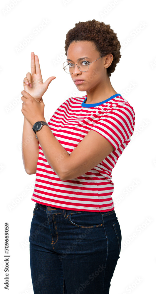 Wall mural beautiful young african american woman wearing glasses over isolated background holding symbolic gun