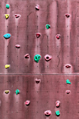 Old abandoned outdoor climbing wall with grips and holds
