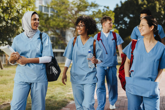 Multicultural medical campus: Happy students going to class together