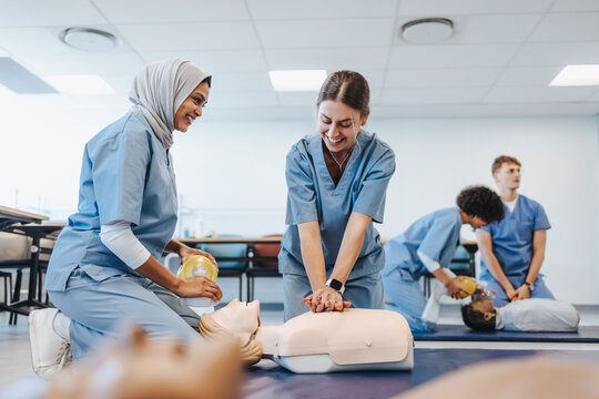Happy medical students undergoing CPR training in clinical simulation