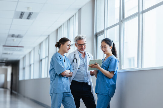 Young medical interns discussing with a senior doctor in a teaching hospital