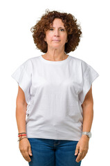 Beautiful middle ager senior woman wearing white t-shirt over isolated background Relaxed with serious expression on face. Simple and natural looking at the camera.