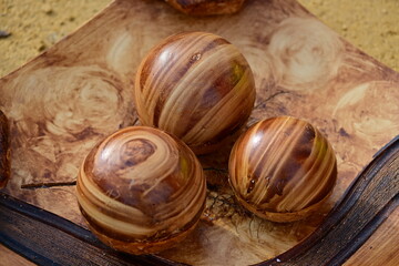 Handmade, old wooden balls with a beautiful structure o a wooden plate.