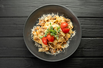 Italian Pasta Fettuccine Bolognese with creamy sauce in black plate. Flat lay.